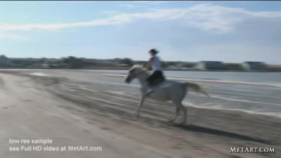 Topless blonde riding a horse